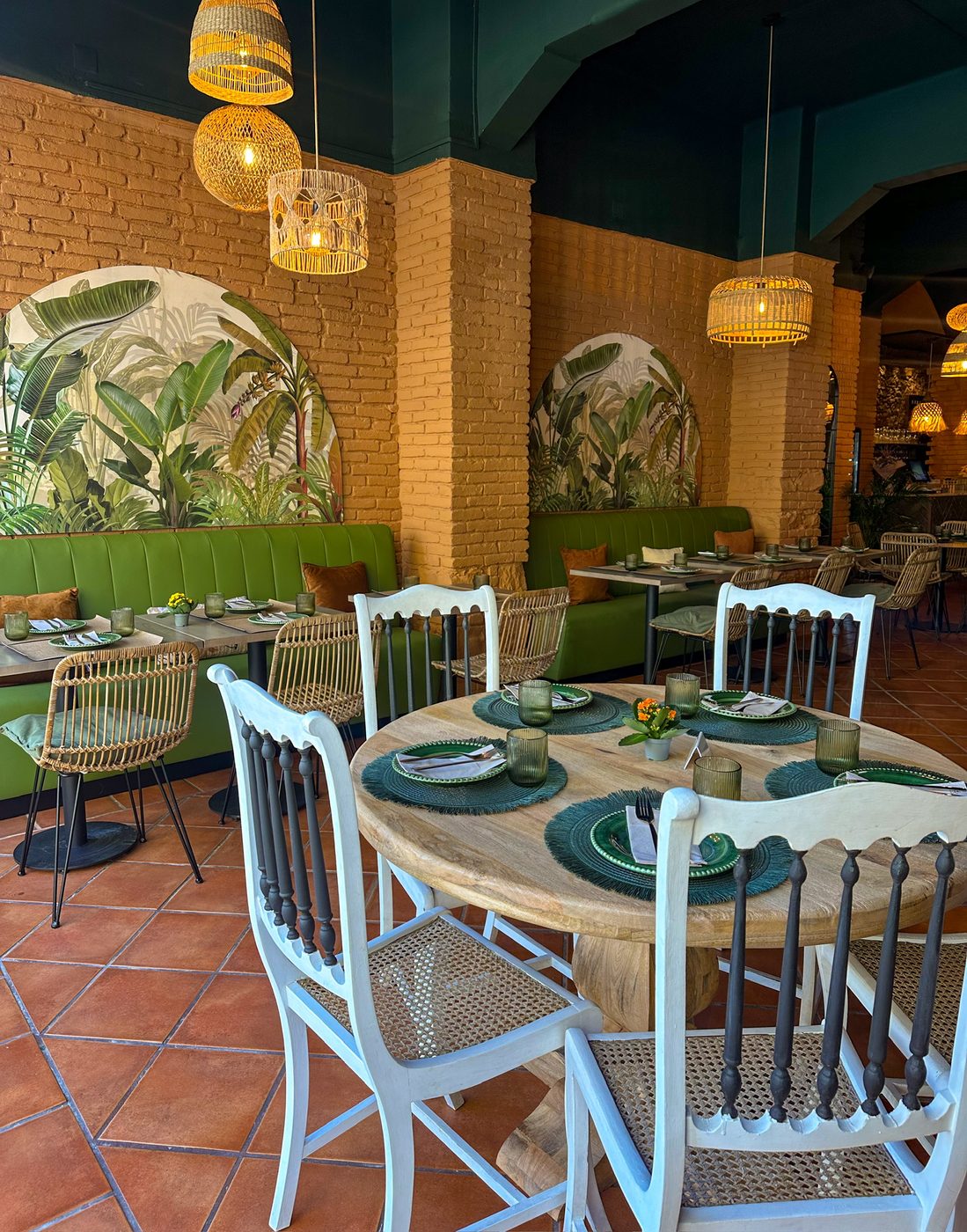 Interior acolhedor do Green Buddha com plantas tropicais, ambiente sereno e alegre, luzes quentes